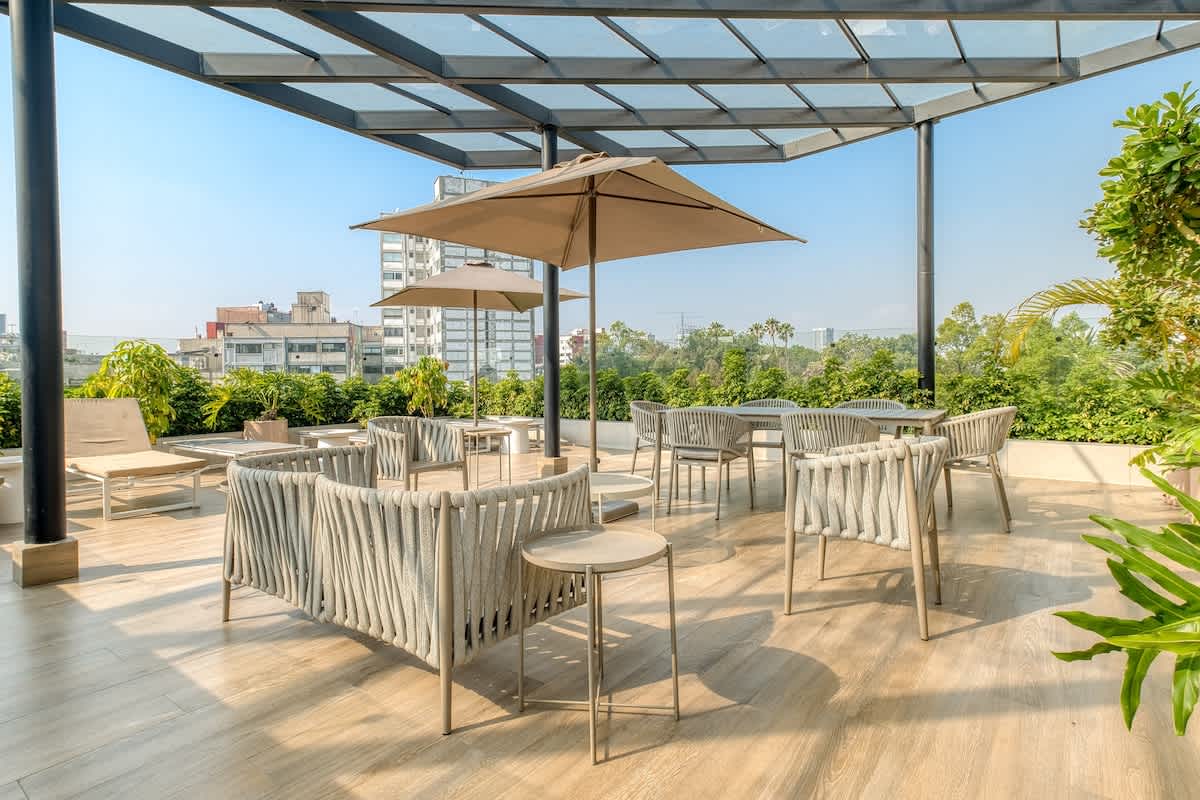 Rooftop terrace with shaded dining and leafy Condesa views, your open-air lounge above the neighborhood
