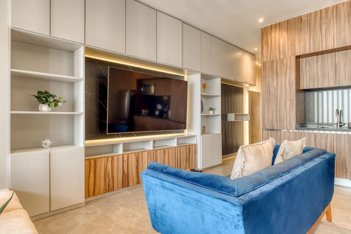 Stylish living space with a smart TV and a plush blue velvet sofa, easy nights on Reforma