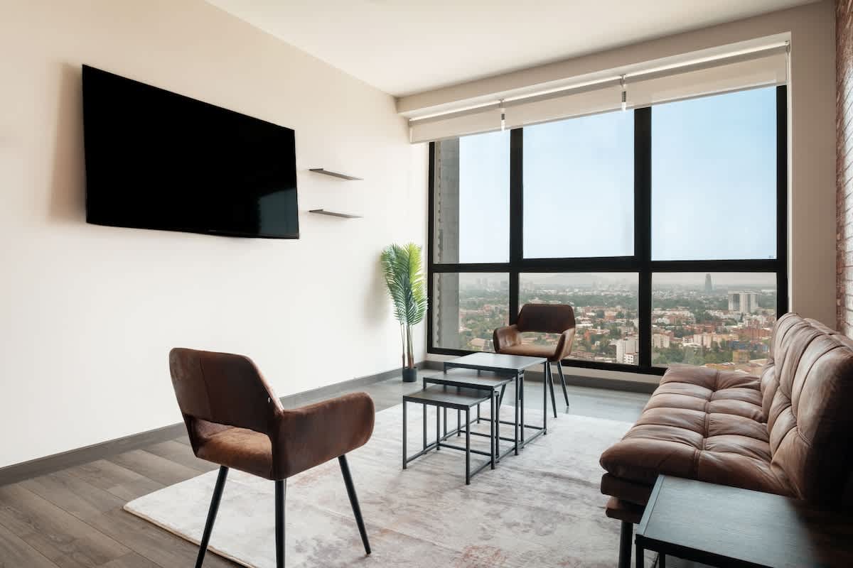 Bright living room with a smart TV, soft sofa and city views, easy downtime in the heart of Polanco