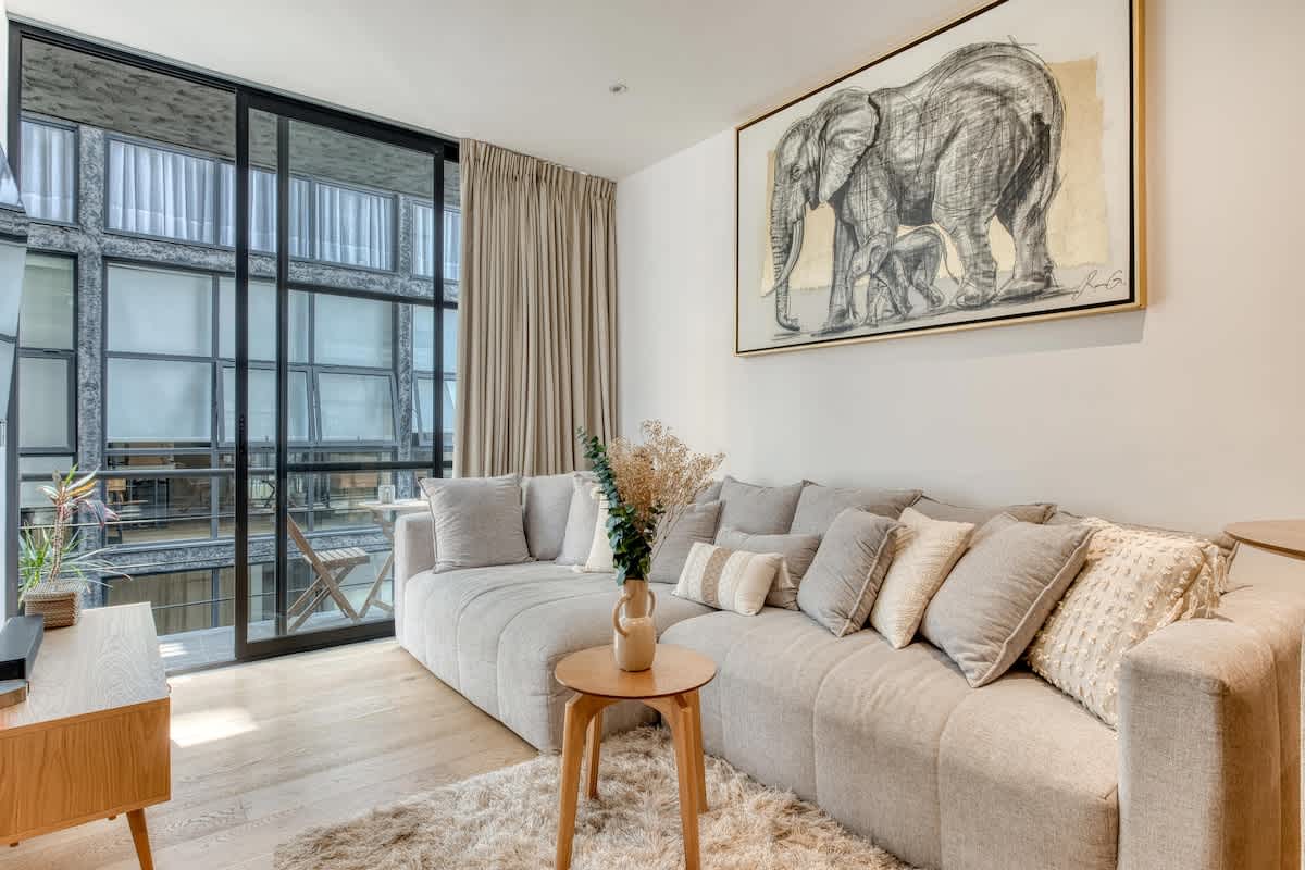 Bright living room with a deep sectional sofa and playful art, easy relaxing in the heart of Roma Norte
