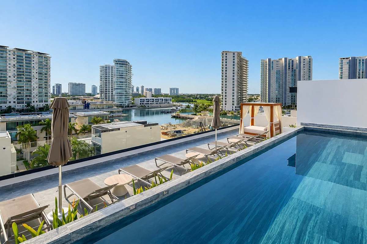 Shared rooftop infinity pool with marina and city views