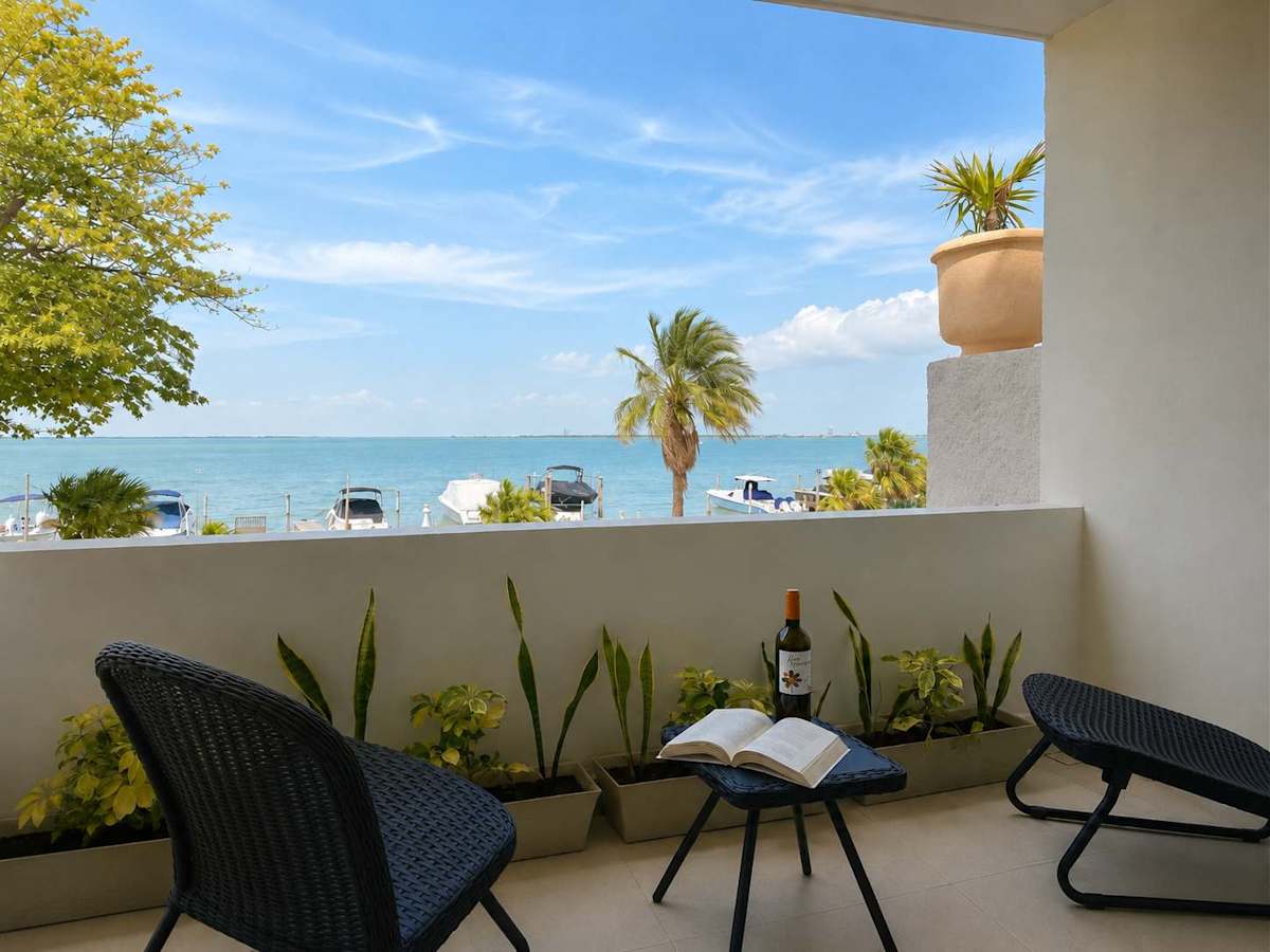 Private balcony with seating and open lagoon views, a serene spot for morning coffee near the Cancun Hotel Zone