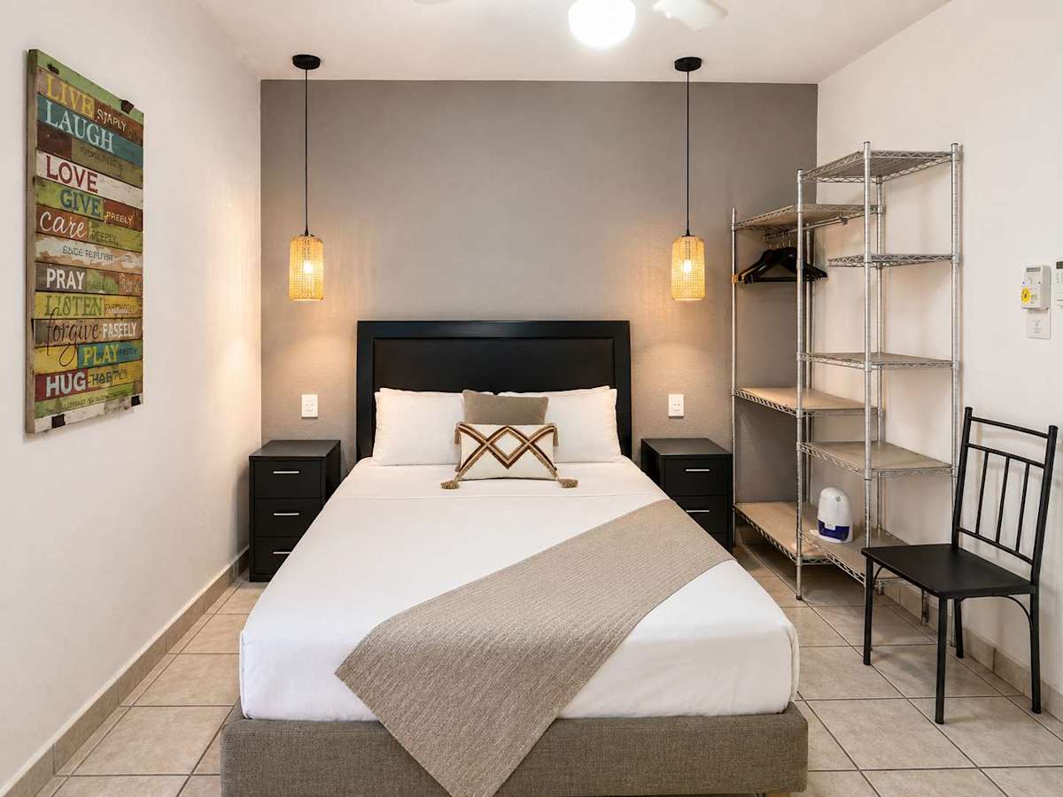 Restful bedroom with a comfy double bed and handy shelving, your quiet retreat after exploring downtown Cancun