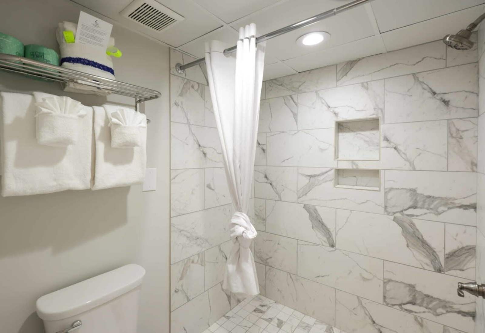 Start your day in this sleek, spa-inspired walk-in shower—where marble vibes meet beachside calm. Plush towels, built-in shelving, and modern touches make this bathroom feel like a mini retreat. 