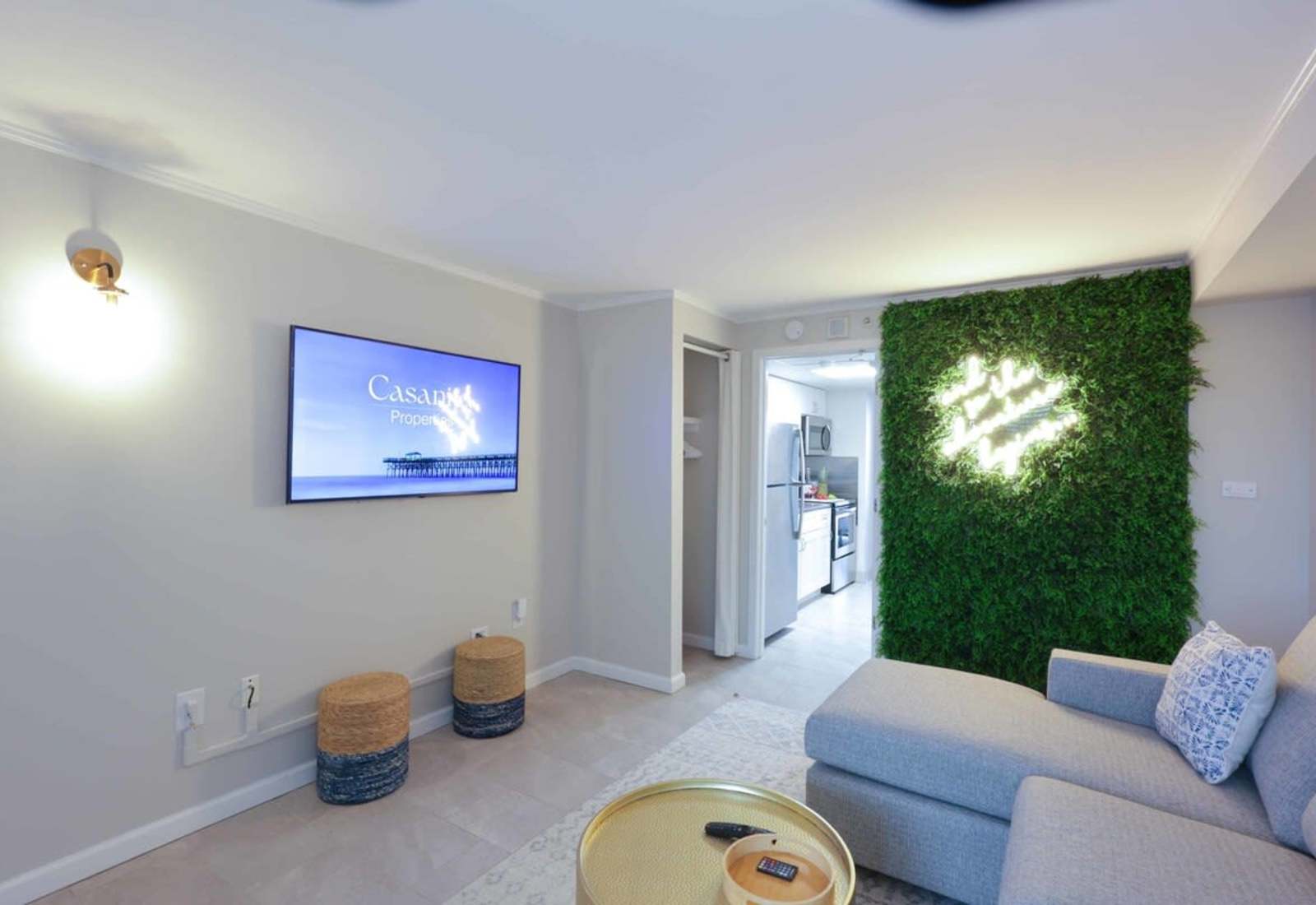 Binge your favorite shows, sip something chilled, and snap a selfie in front of the neon-lit moss wall—this living space is giving major vacation vibes with a side of style. 