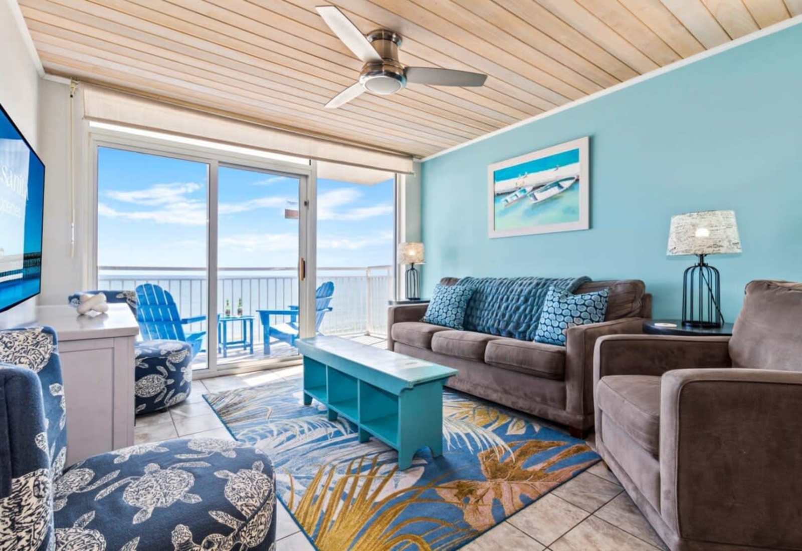 Step into this inviting living space with vibrant coastal decor, plush seating, and a private balcony showcasing breathtaking ocean views. 