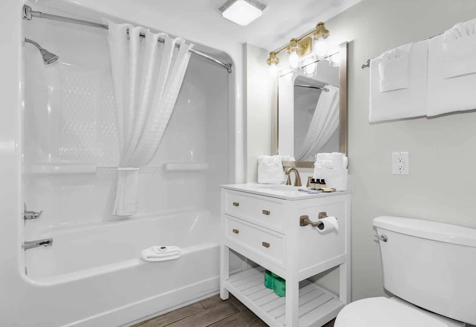 Step into this fresh and inviting bathroom, complete with a tub-shower combo and vibrant coastal accents. Enjoy plush towels, complimentary toiletries, and a thoughtful design that makes your stay both comfortable and convenient.