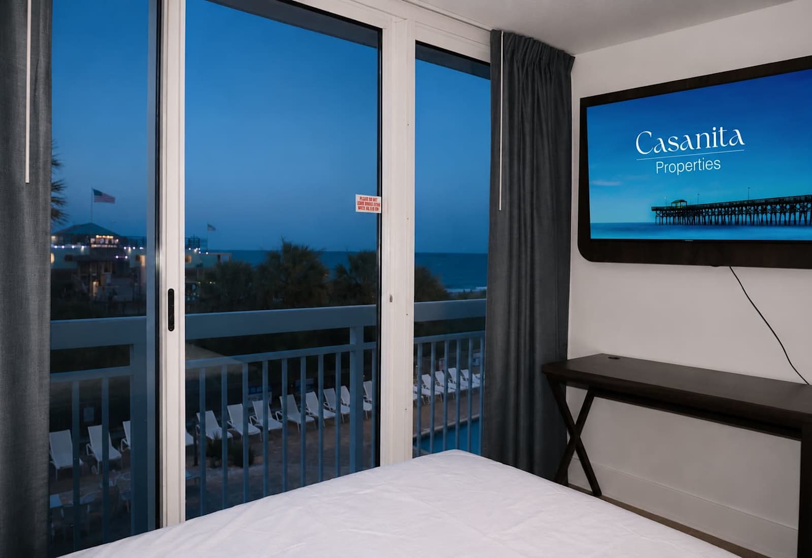 Watch the sun fade into twilight as the sparkling lights of the nearby pier transform your ocean view into an unforgettable evening escape.