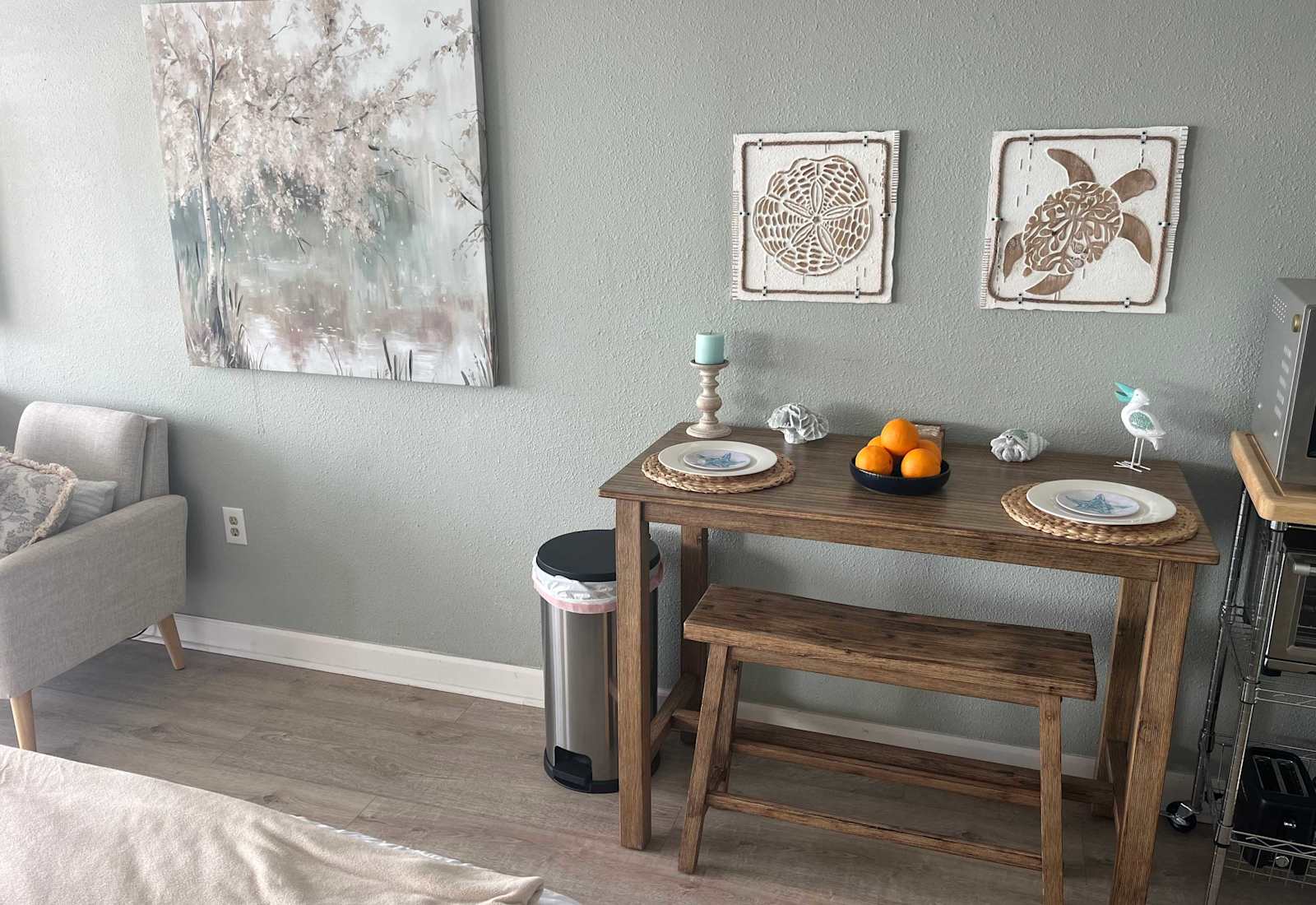 Charming wooden dining nook with a bench, coastal wall art, and table settings
