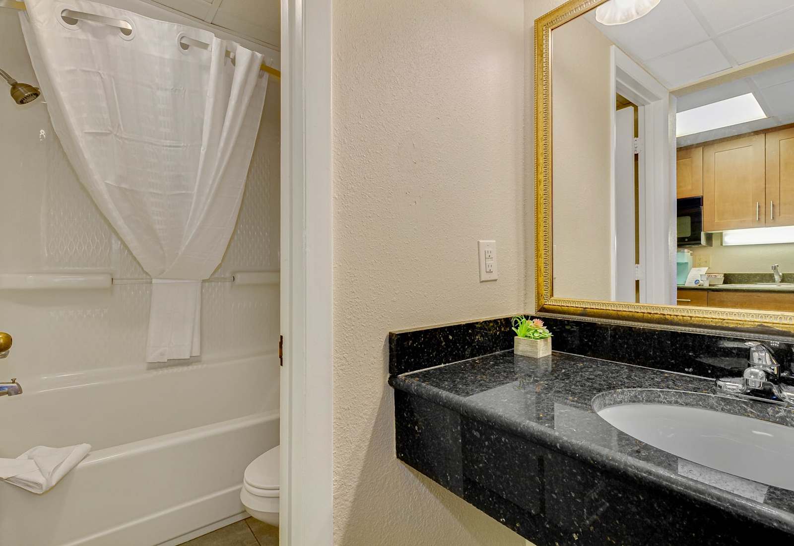 Relax in a clean and modern bathroom with a shower/tub combo and granite countertop vanity. 

