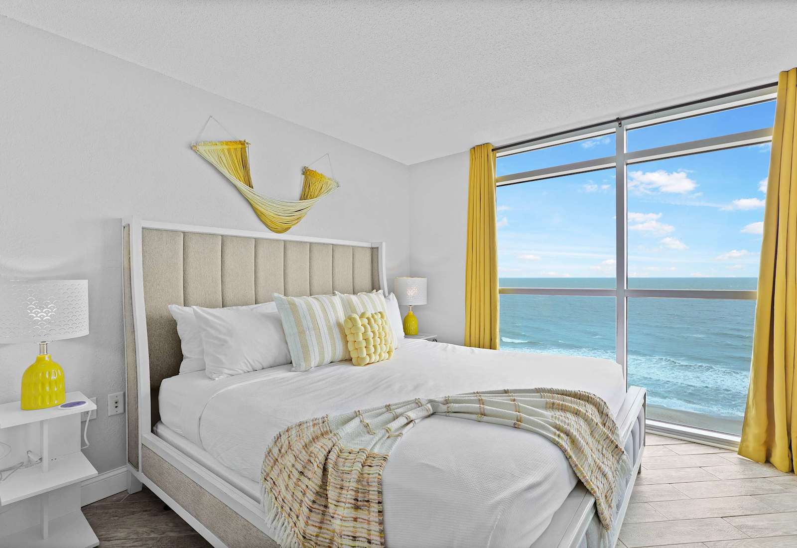 Wake up to panoramic ocean views in this sunlit, coastal-chic bedroom! Featuring a plush king bed, bright yellow accents, and floor-to-ceiling windows, it’s the perfect Myrtle Beach retreat for rest and relaxation.