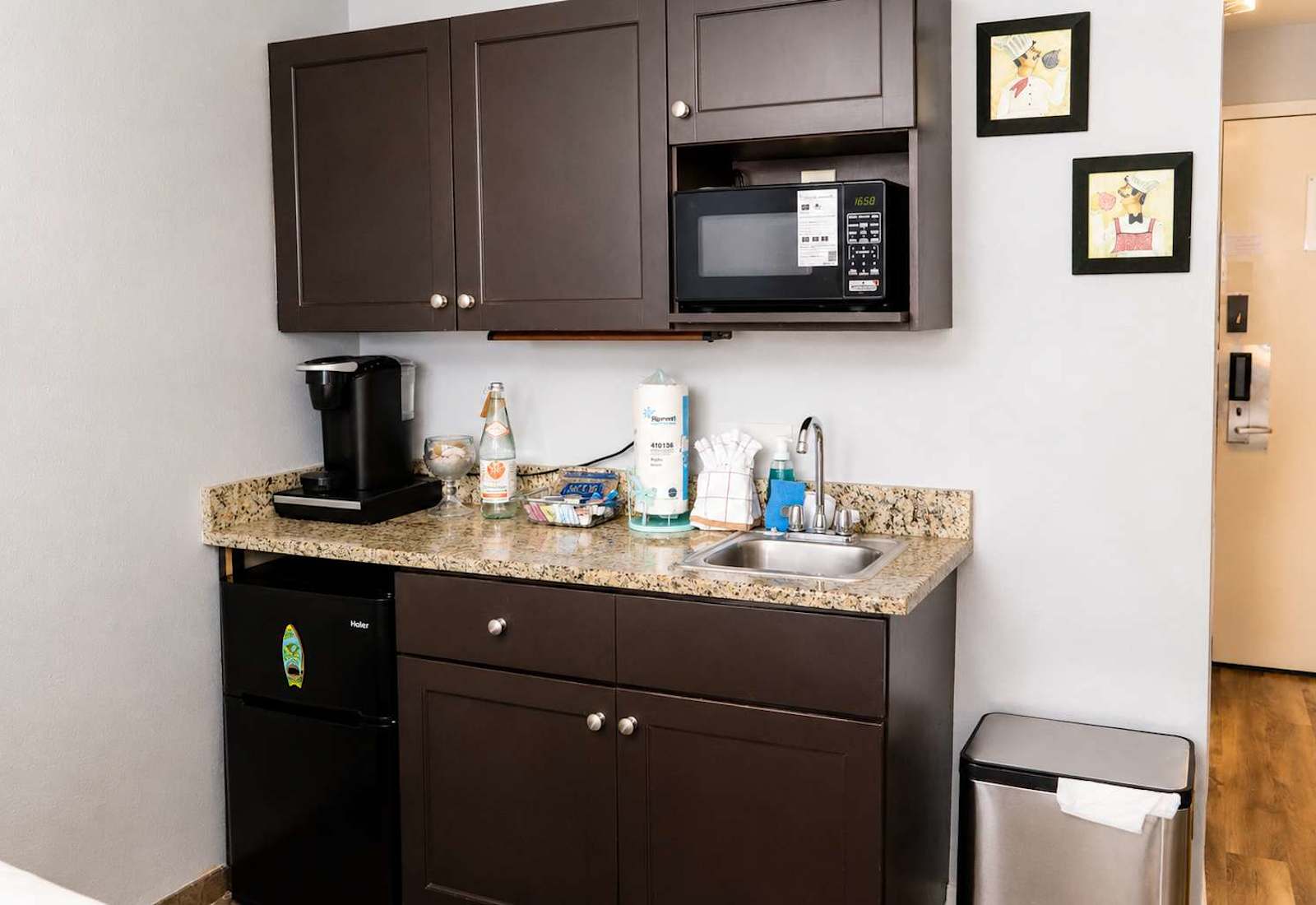 Compact kitchenette station equipped with a microwave, coffee maker, sink, and mini fridge