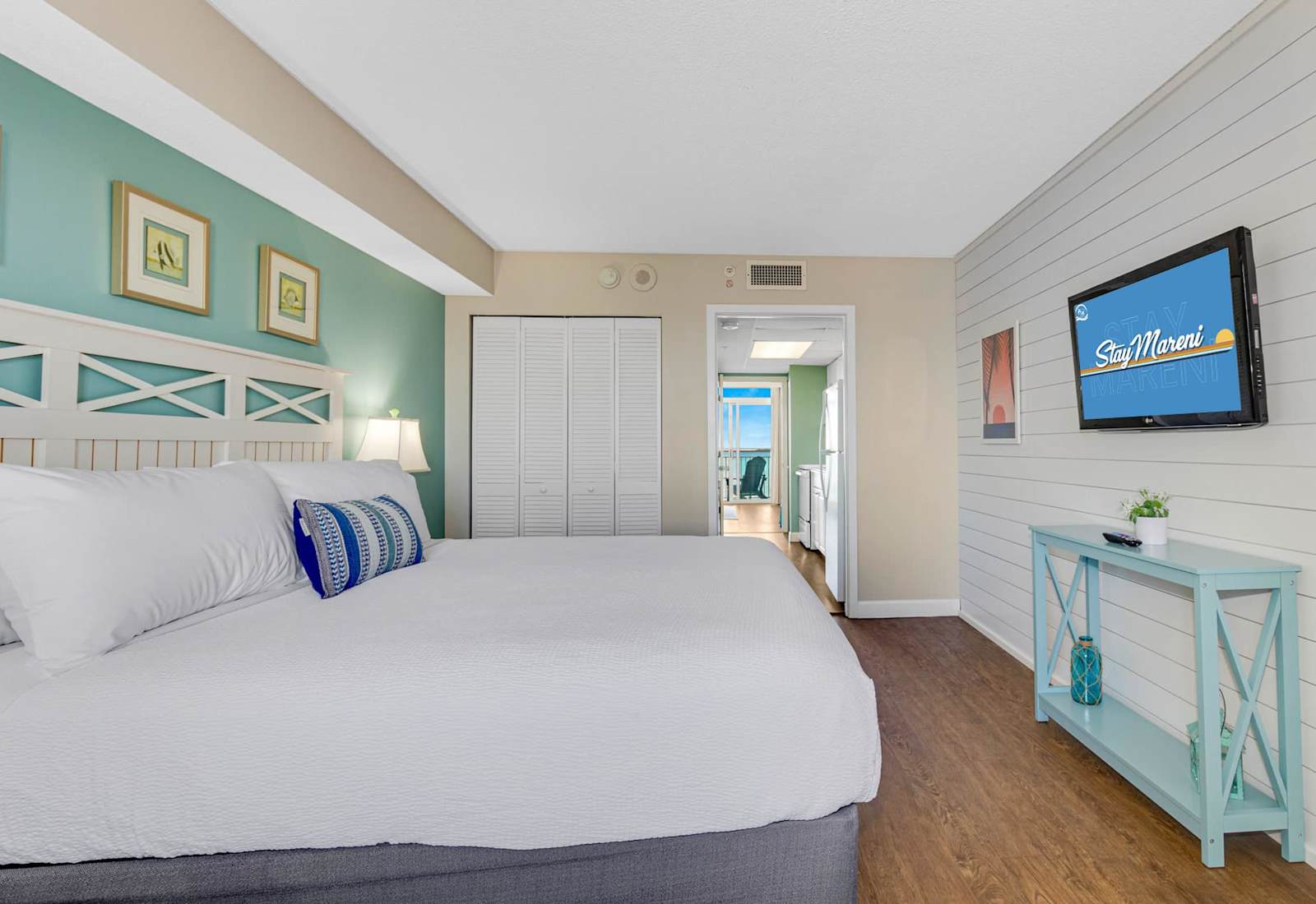 Relax in style in this serene bedroom featuring a plush king-sized bed, soothing coastal decor, and ample natural light. Drift off to the sound of the waves and wake up refreshed, just steps away from breathtaking ocean views. 