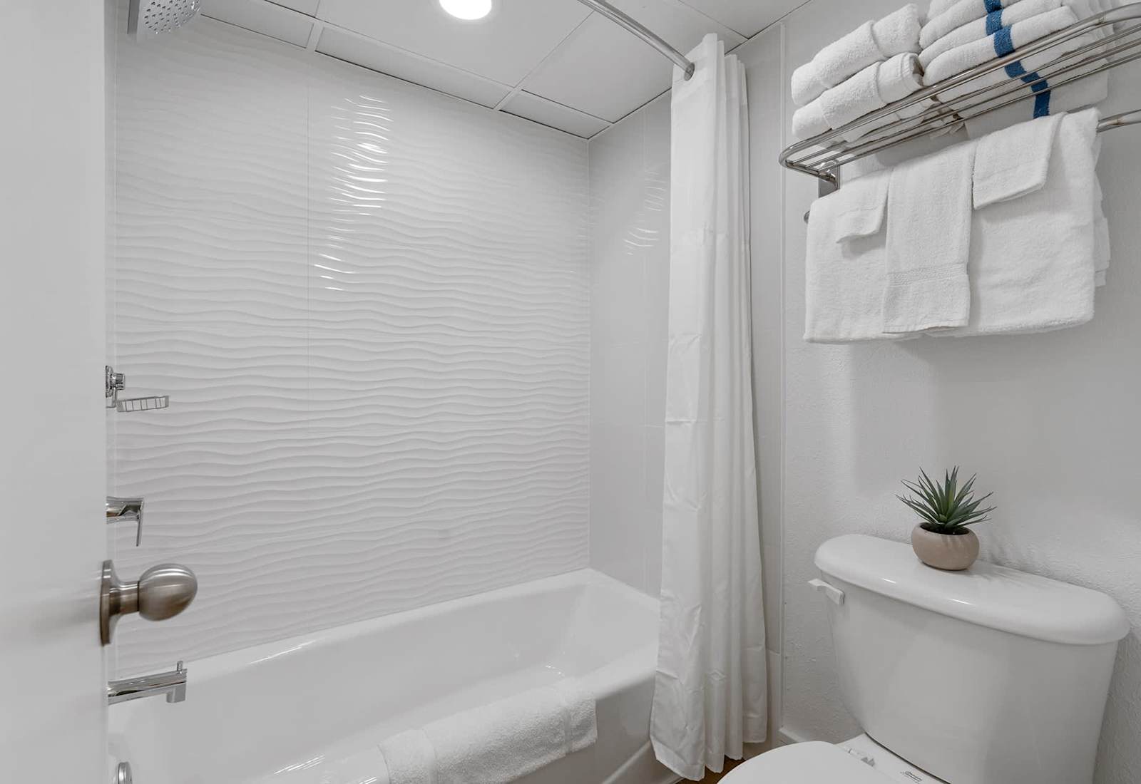 With a separate vanity outside the bathroom for additional privacy, this bathroom features a spacious bathtub, plush towels, and a calming white and blue color scheme. And the high quality toiletries make it feel like a trip to the day spa!
