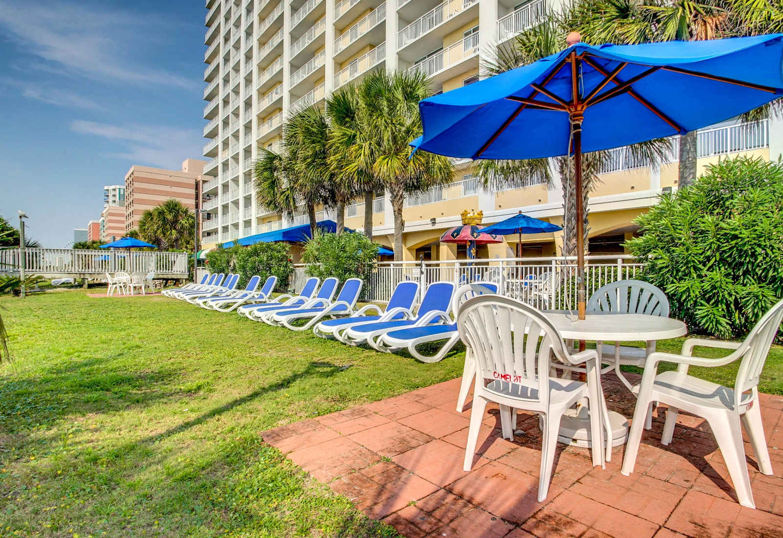 Relax in style with comfortable lounge chairs and shaded tables, perfect for enjoying the outdoors. Whether soaking up the sun or unwinding with a meal, this space is ideal for a peaceful retreat.