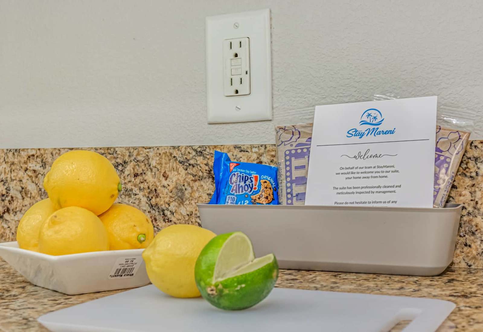 Thoughtful welcome touches on the kitchen counter, with fresh citrus, snacks, and a warm note to help guests feel at home upon arrival.