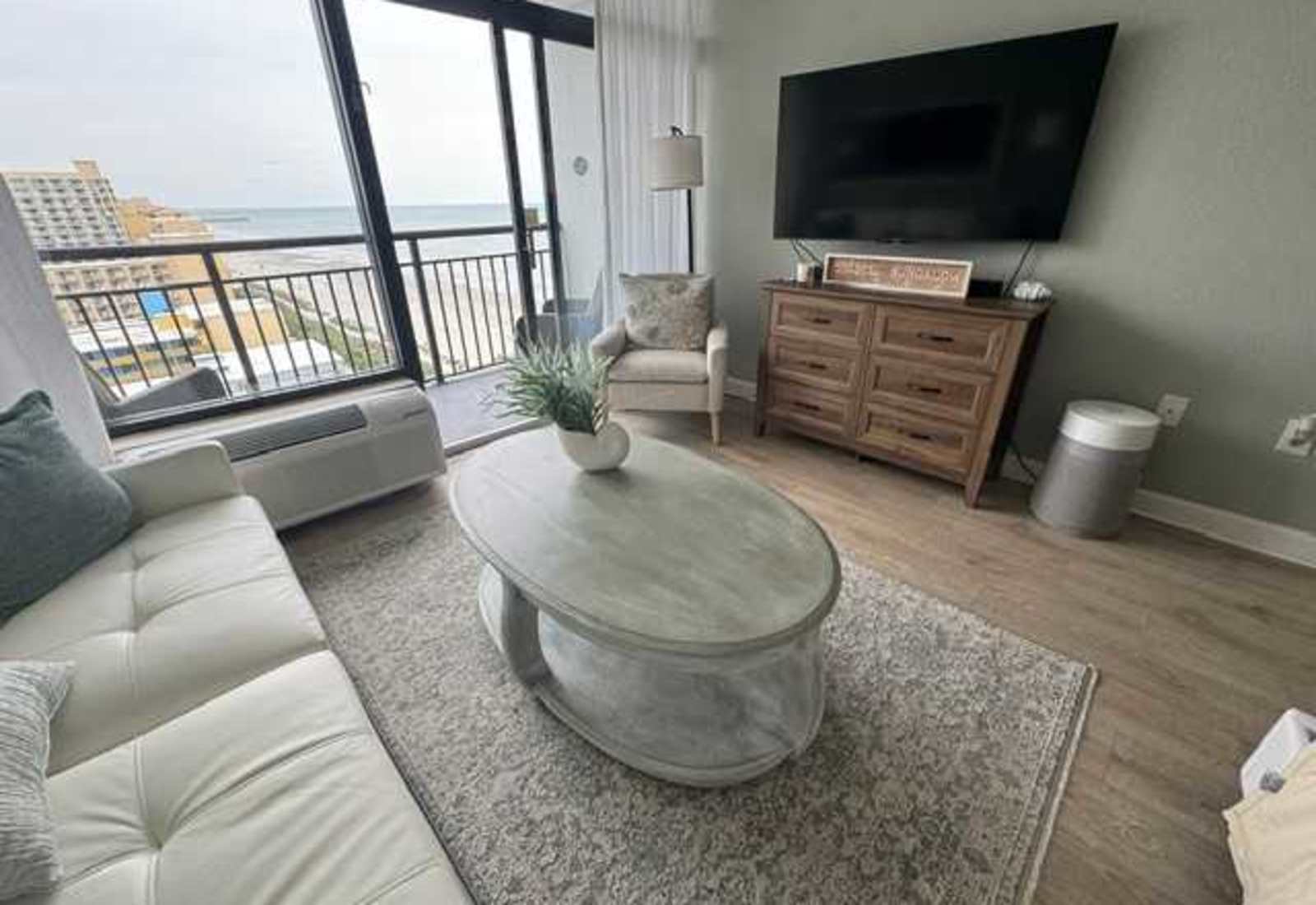 Relaxing living space featuring a large smart TV and direct balcony access with ocean views
