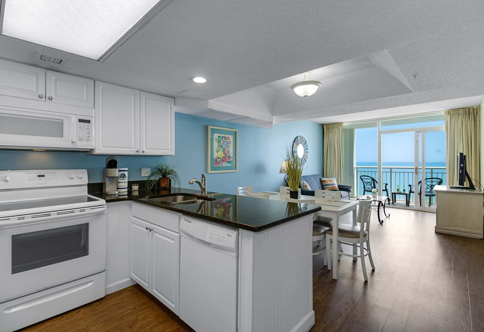 Cook up a meal or enjoy a coffee in this fully equipped kitchen, featuring modern appliances and a spacious counter. With a dining area that opens to ocean views, it’s the perfect spot to relax and enjoy your stay.