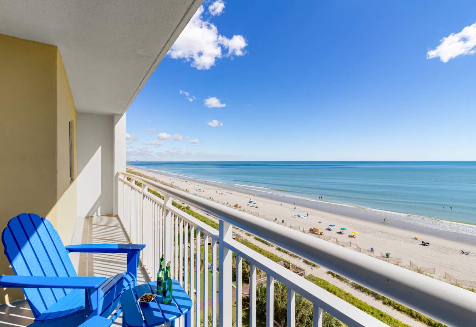 Enjoy a slice of paradise from this stunning beachfront balcony. Relax in vibrant Adirondack chairs, sipping your favorite drink while overlooking miles of pristine sands and sparkling waters. It's the perfect spot for unforgettable seaside moments.