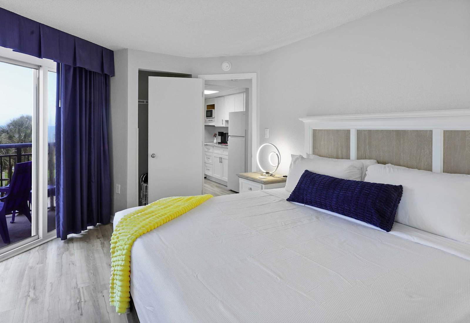 Wake up to palm tree views and ocean breezes from this bright and airy bedroom. With a plush king bed, soft lighting, and easy kitchen access, it’s your own slice of beachside bliss.