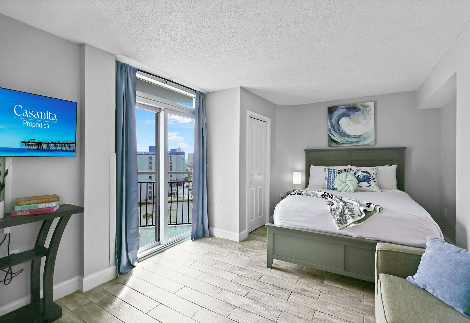 Relax in this serene coastal bedroom featuring a comfy bed, stylish decor, smart TV, and private balcony access. The perfect blend of comfort and charm for your Myrtle Beach escape!