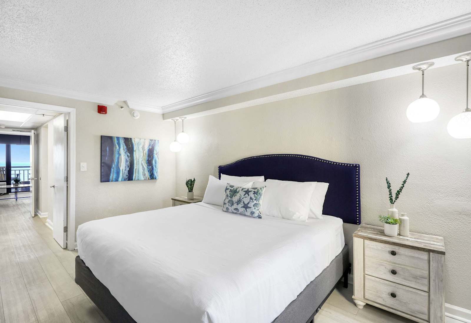 Unwind in comfort with this serene king bedroom, featuring soft lighting, coastal-inspired decor, and a plush mattress for a restful sleep. Wake up refreshed with a peek of the ocean just down the hall.
