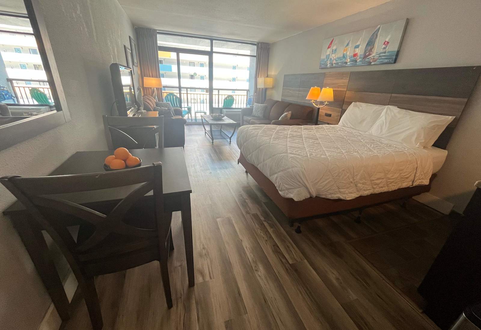 Open-concept studio living space featuring a dining area, cozy seating, and a plush bed.