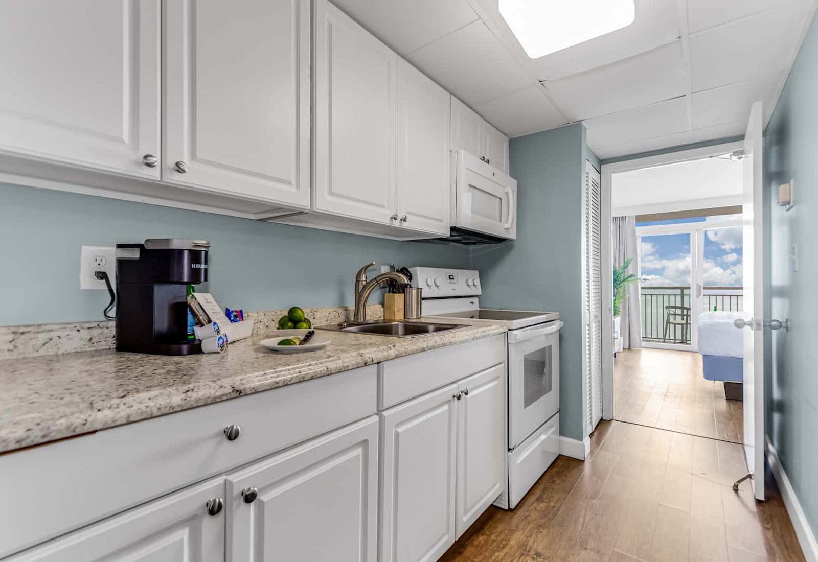 Cook with ease in this fully equipped kitchen featuring modern appliances and sleek countertops. Perfect for preparing your favorite meals while enjoying ocean views in the background.