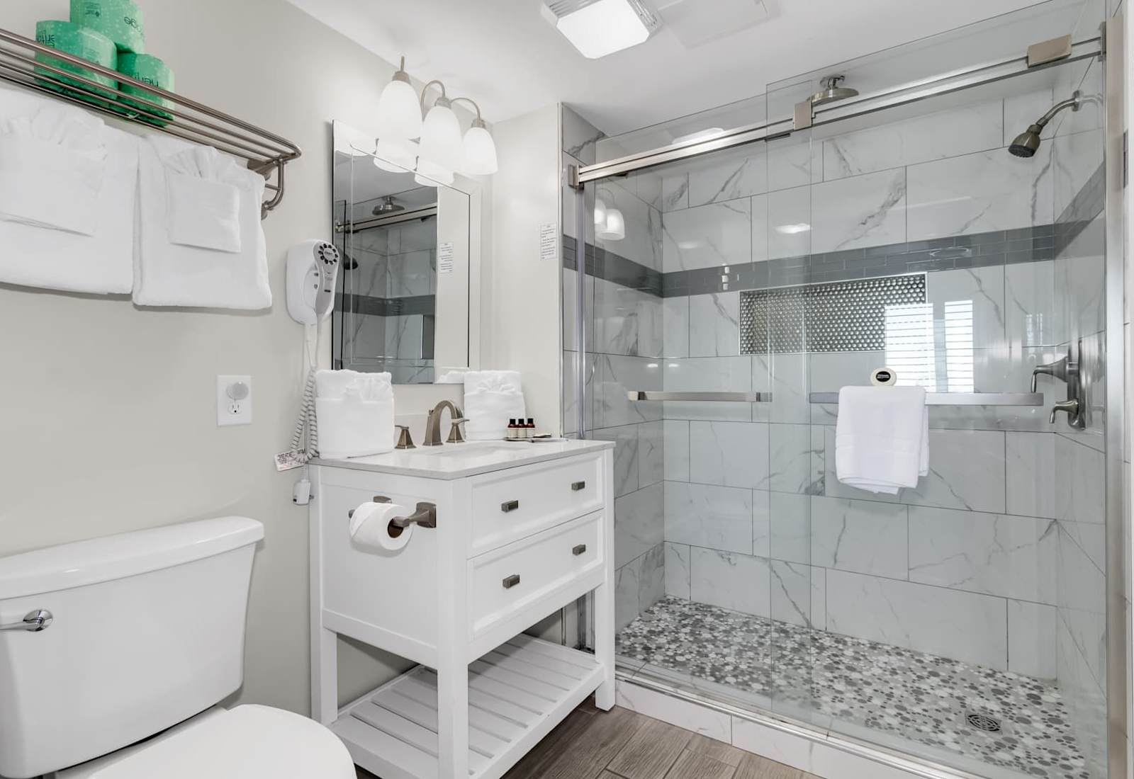 Step into a spa-like experience in this luxurious bathroom. Featuring a sleek glass-enclosed shower, elegant marble tiles, and plush amenities, it’s the perfect space to refresh and unwind after a day by the beach.