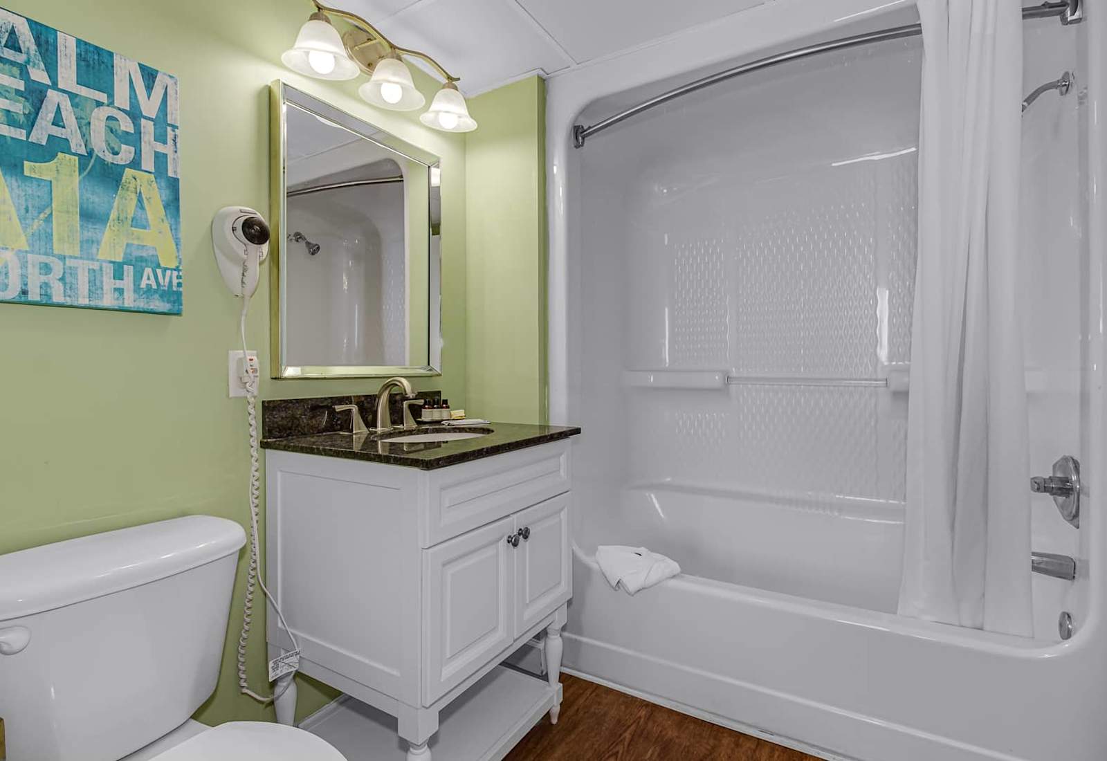 Step into this bright and fresh bathroom, complete with modern fixtures, a granite vanity, and a sparkling clean tub. The perfect spot to refresh and unwind after a day by the beach.