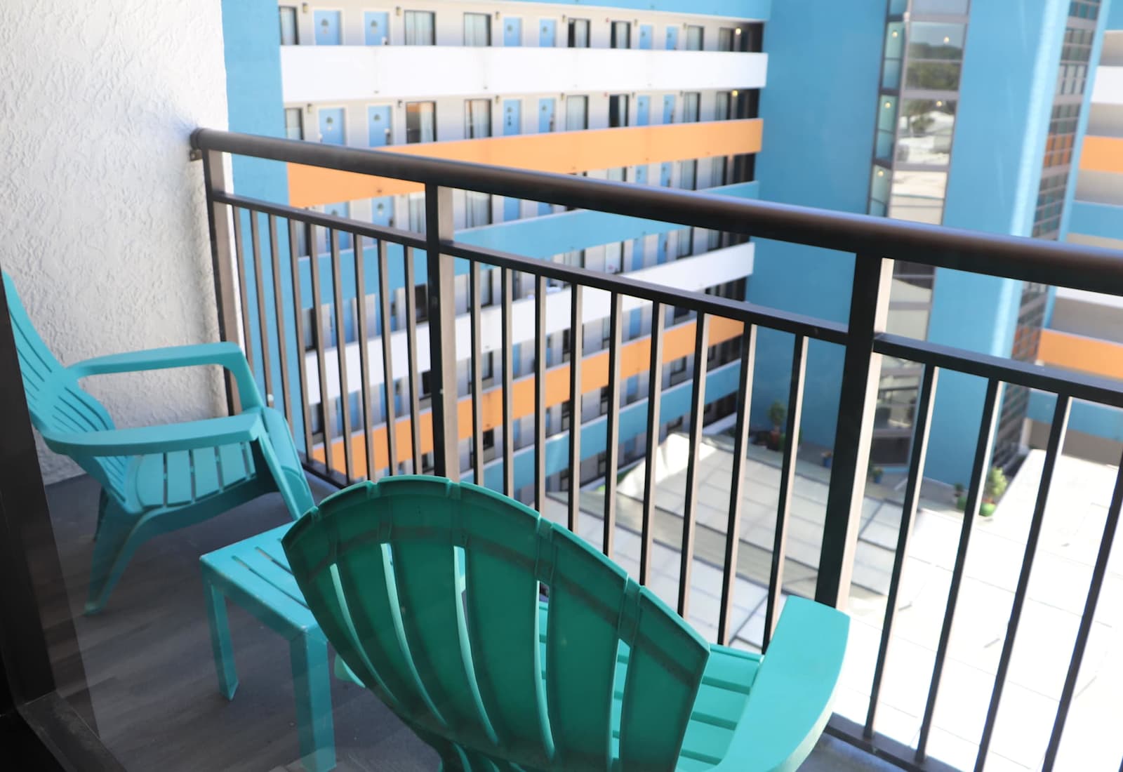 Private balcony featuring colorful Adirondack chairs and a small table overlooking the resort complex