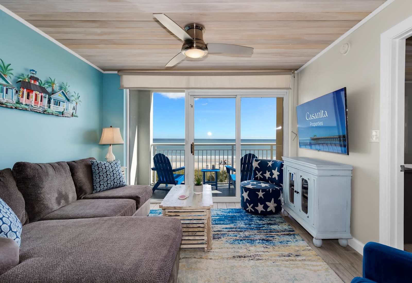 Unwind in this coastal-inspired living room with cozy seating, charming decor, and floor-to-ceiling views of the ocean. Step onto the balcony to feel the sea breeze or relax indoors with all the comforts of a stylish beachside retreat.