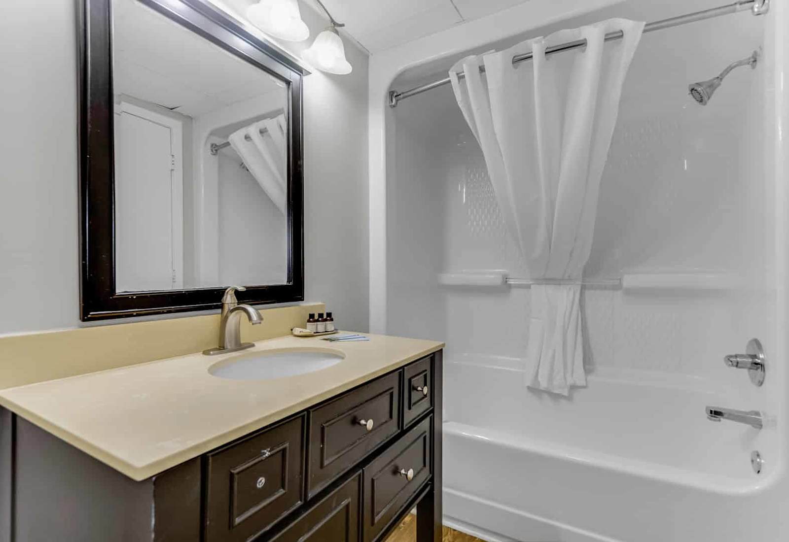 Refresh and relax in this modern bathroom featuring a spacious tub-shower combo and sleek vanity with thoughtful amenities included for your comfort.