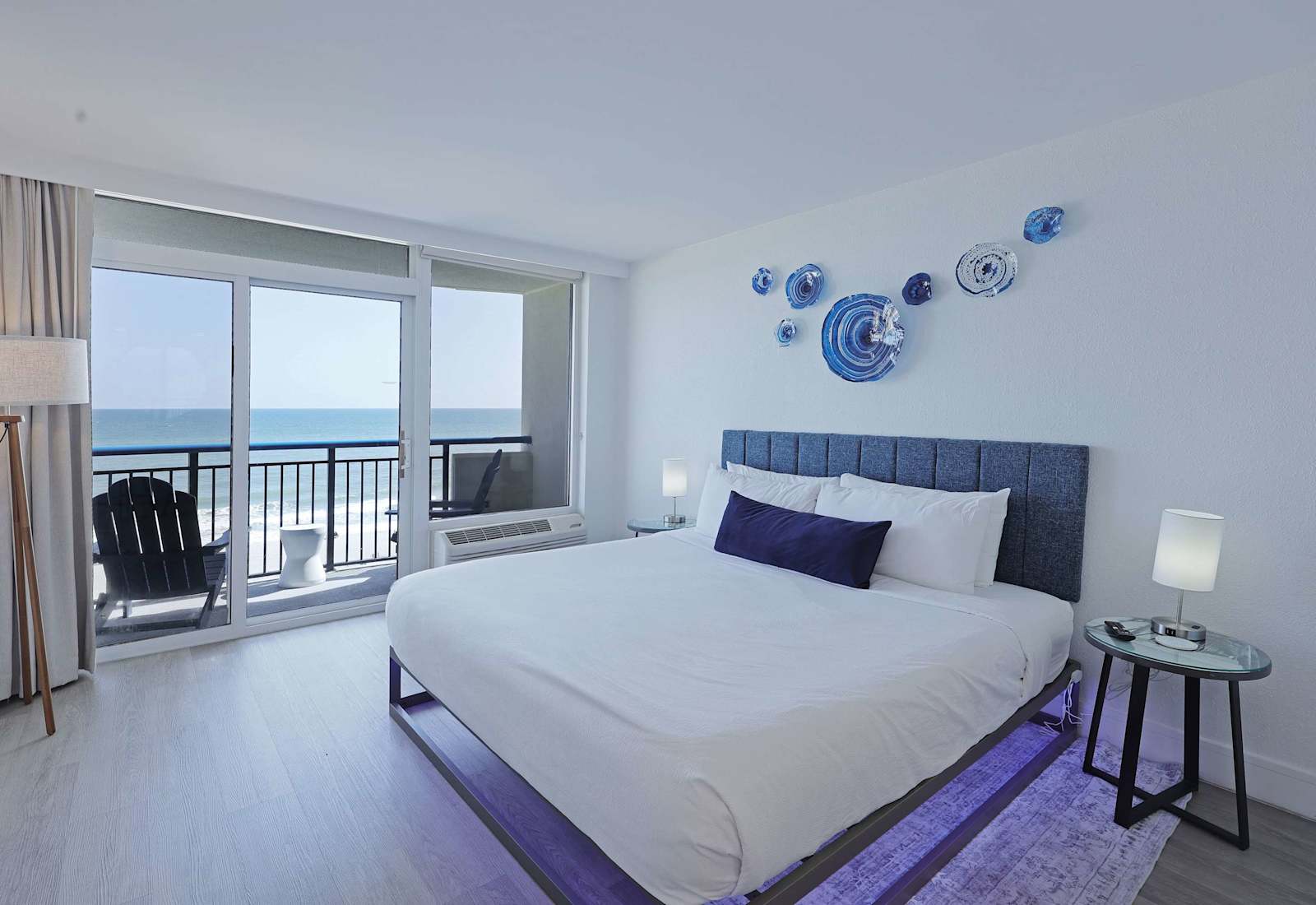 Wake up to stunning ocean views from this bright and modern bedroom, featuring a plush king bed, soft linens, and direct balcony access for the perfect start to your beach day.