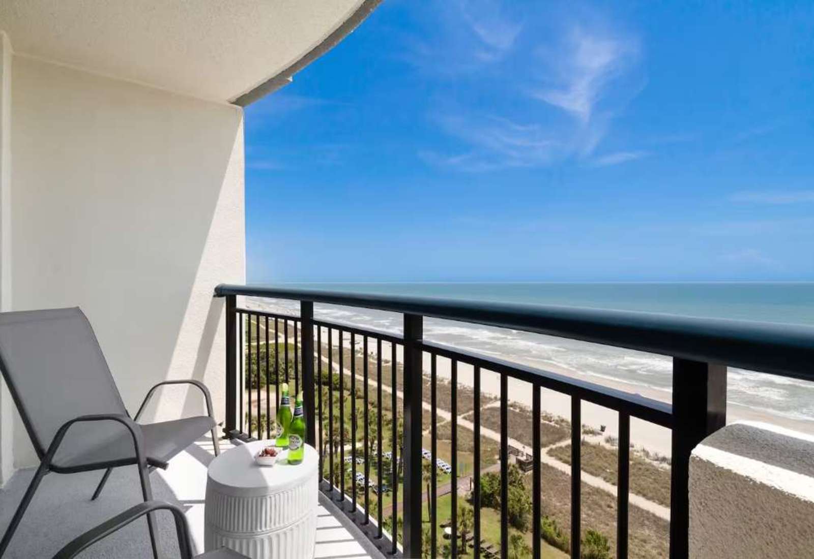 Step out onto your private balcony and soak in panoramic ocean views. With comfortable seating and a side table perfect for snacks or drinks, this serene spot invites you to unwind and enjoy the gentle sea breeze and the calming sound of the waves.