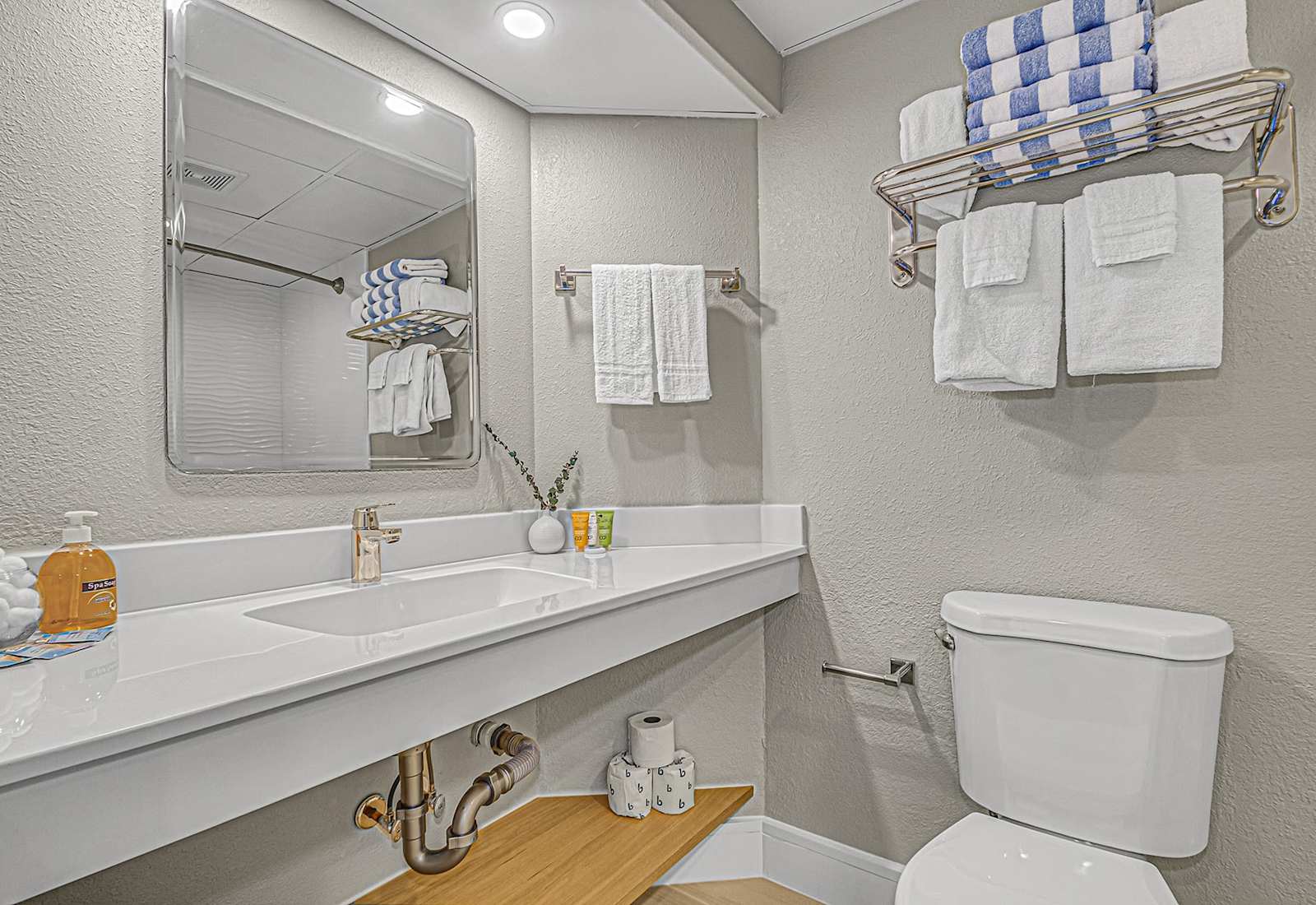 Refresh in this spotless bathroom featuring a wave-textured wall that includes plush towels.