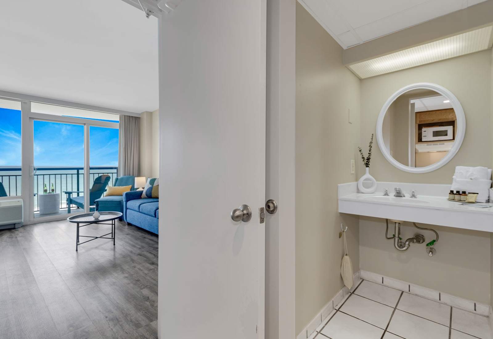 Enjoy a bright, modern bathroom featuring marble-style tile, sleek fixtures, and a spacious vanity—perfect for refreshing after a beach day or getting ready for a night out on the coast.