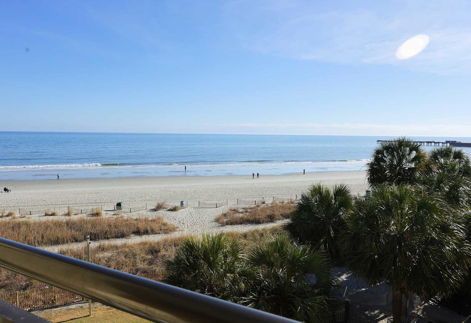 Beautiful oceanfront view from the balcony, with direct sightlines of the beach, coastline, and Myrtle Beach pier — the perfect backdrop for a relaxing coastal escape.