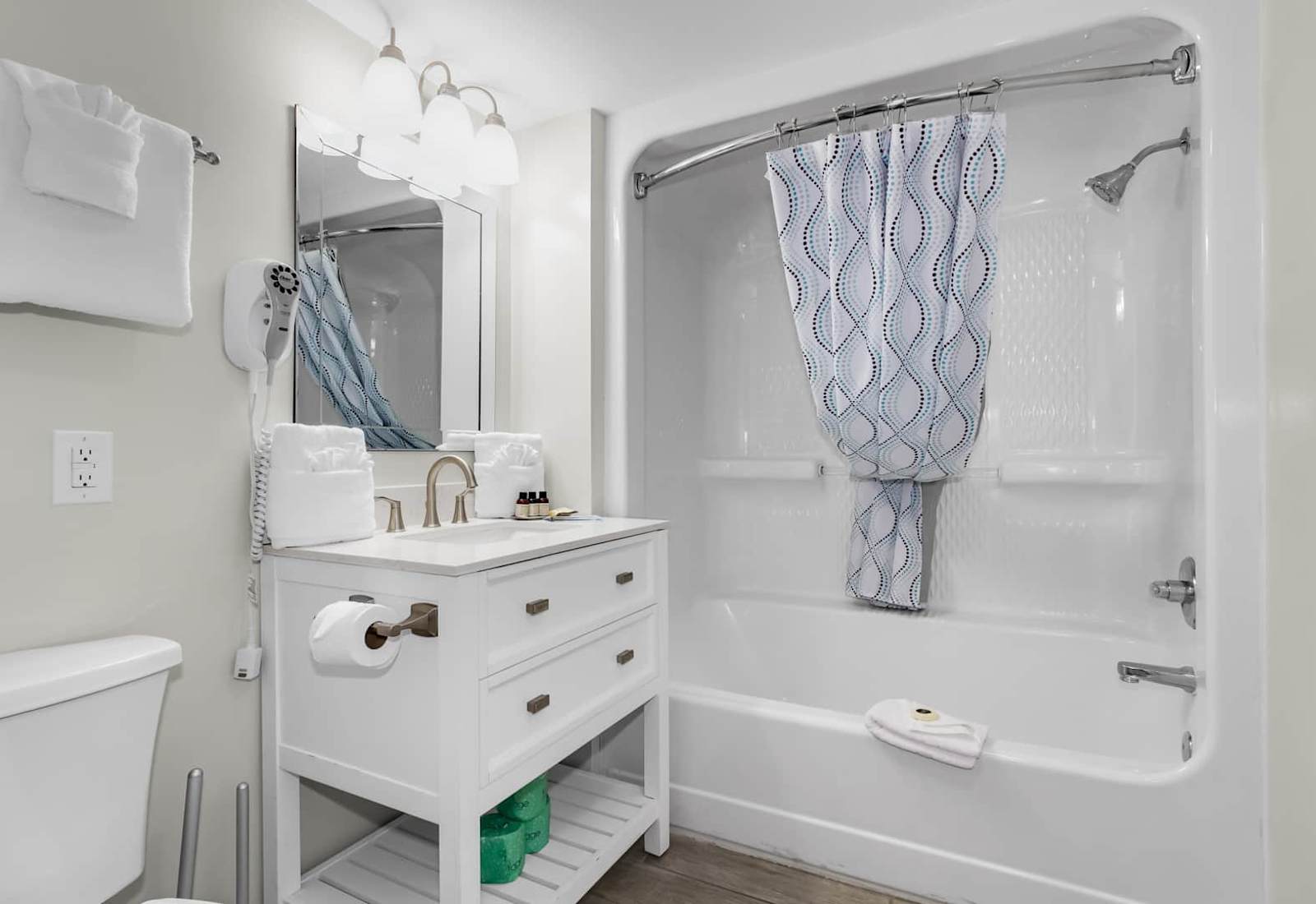 Freshen up in this bright and modern bathroom featuring a sparkling clean tub and shower, plush towels, and elegant vanity. Perfectly appointed for a refreshing start to your day or a relaxing evening soak after a day by the beach.