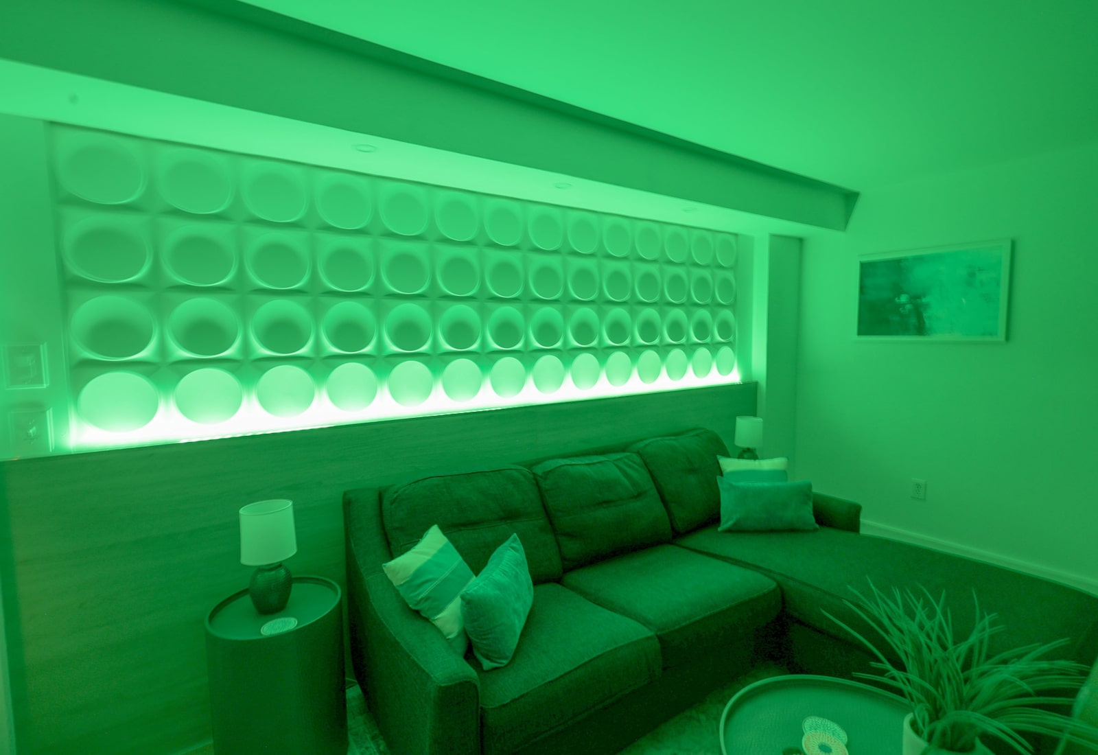 Relax in this stylish living area featuring modern decor, warm lighting, and a cozy sectional sofa—perfect for unwinding after a day at the beach or enjoying a quiet evening with family and friends.