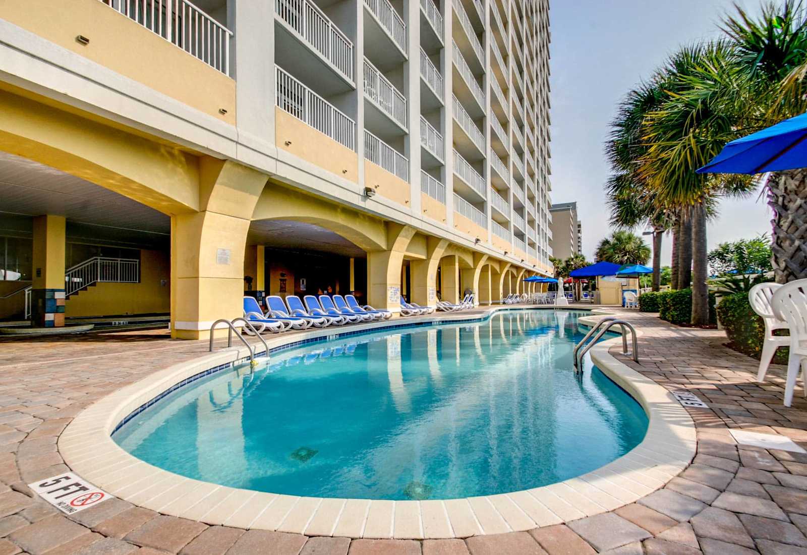 Take a refreshing dip in this inviting pool, perfectly situated under the building's shade for a cool retreat. With comfortable lounge chairs and a relaxed vibe, it’s the perfect spot to unwind after a fun day at the beach. 
