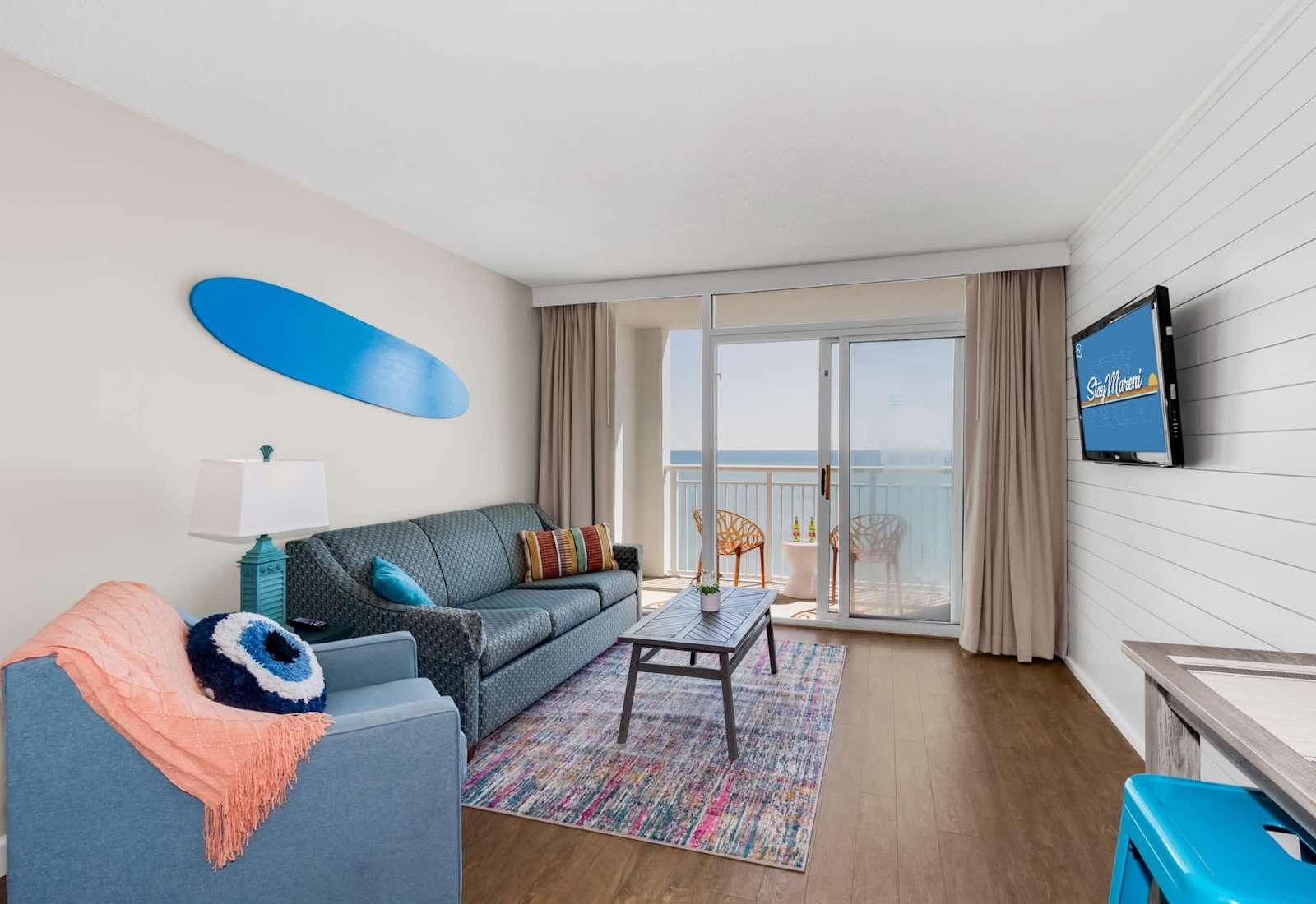 Bright, colorful, and full of charm, this cozy living area is perfect for relaxing after a day at the beach. Enjoy the ocean view from the balcony, cheerful decor, and comfortable seating that makes your stay as inviting as it is memorable.