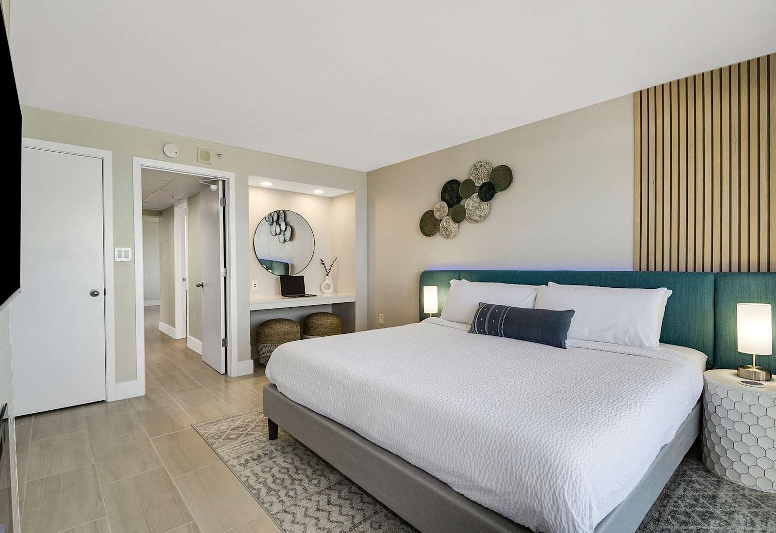 Retreat to this elegant bedroom featuring a luxurious king bed, chic decor, and a cozy vanity nook. 