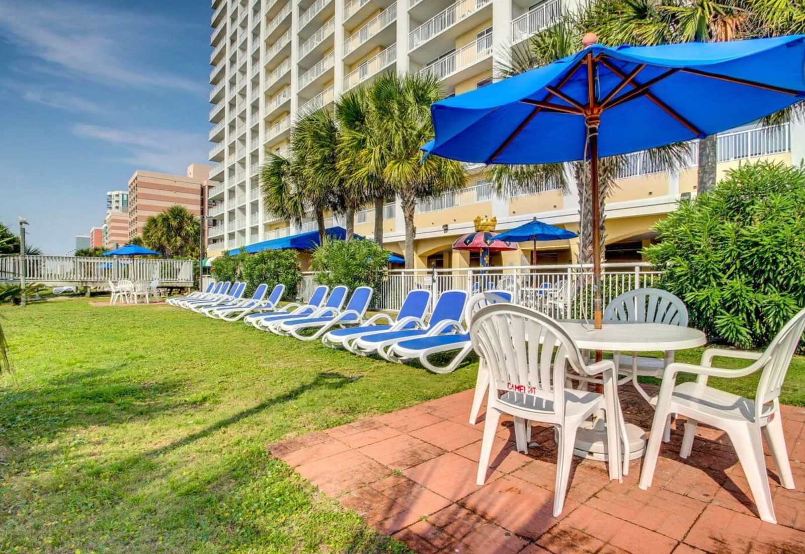 Relax in style with comfortable lounge chairs and shaded tables, perfect for enjoying the outdoors. Whether soaking up the sun or unwinding with a meal, this space is ideal for a peaceful retreat.