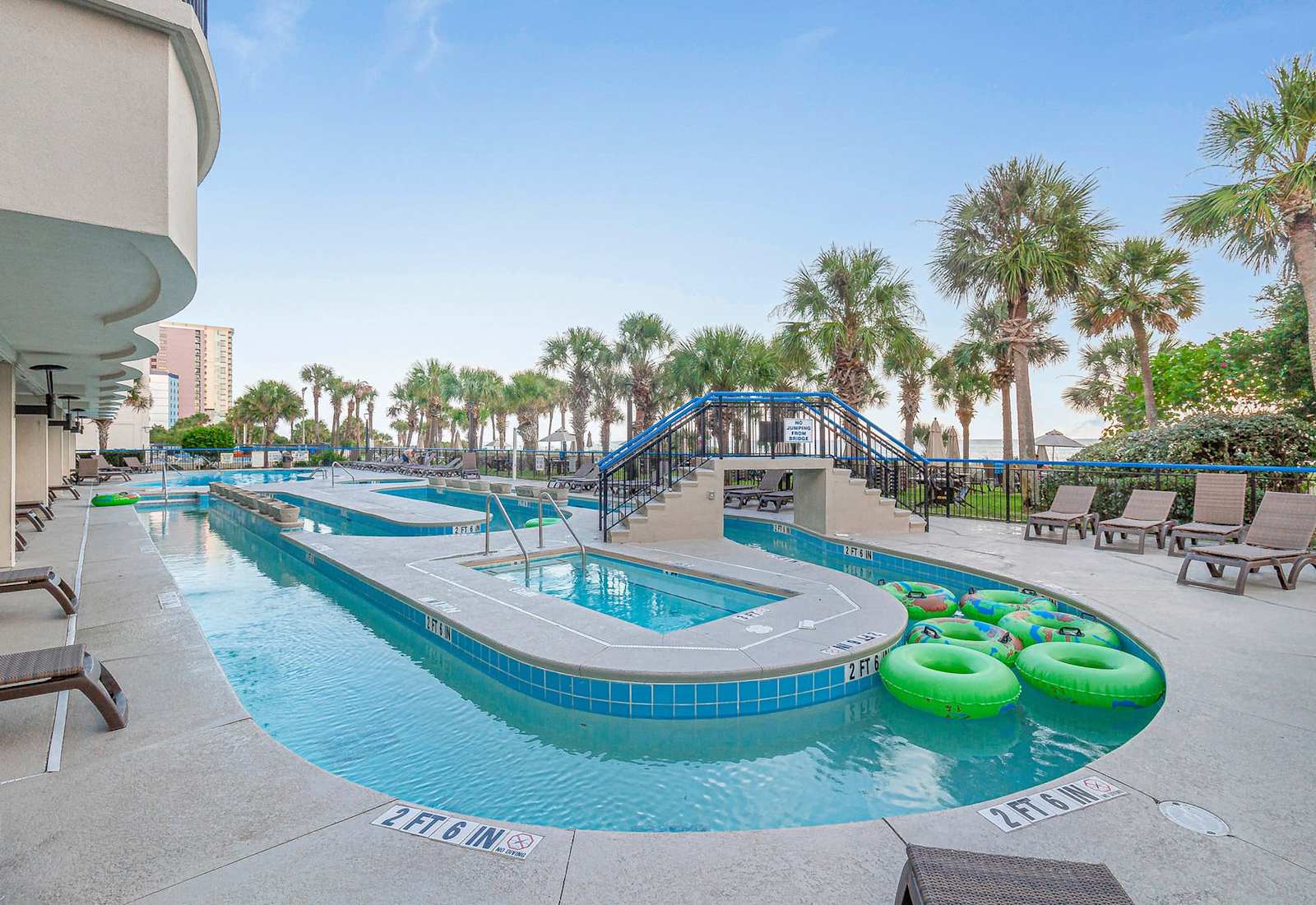 Relax and unwind in this scenic outdoor area featuring a lazy river, bubbling hot tubs, and plenty of lounge chairs. Surrounded by palm trees and just steps from the beach, it’s the perfect spot to soak up the sun and enjoy a laid-back day.