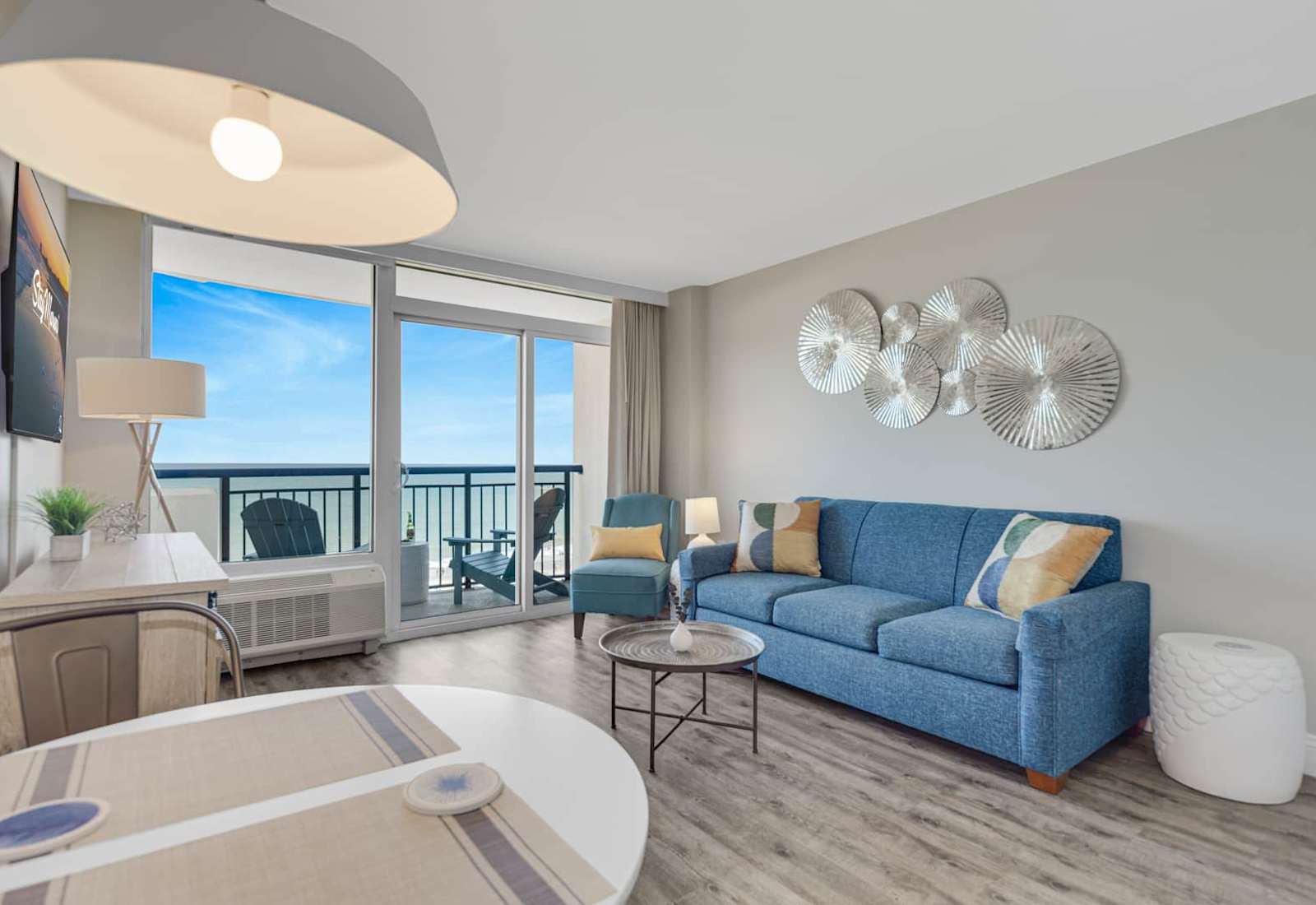 Relax with breathtaking ocean views from this bright, open living space—featuring a cozy sectional, beach-inspired décor, and a private balcony perfect for morning coffee or sunset wine by the sea.