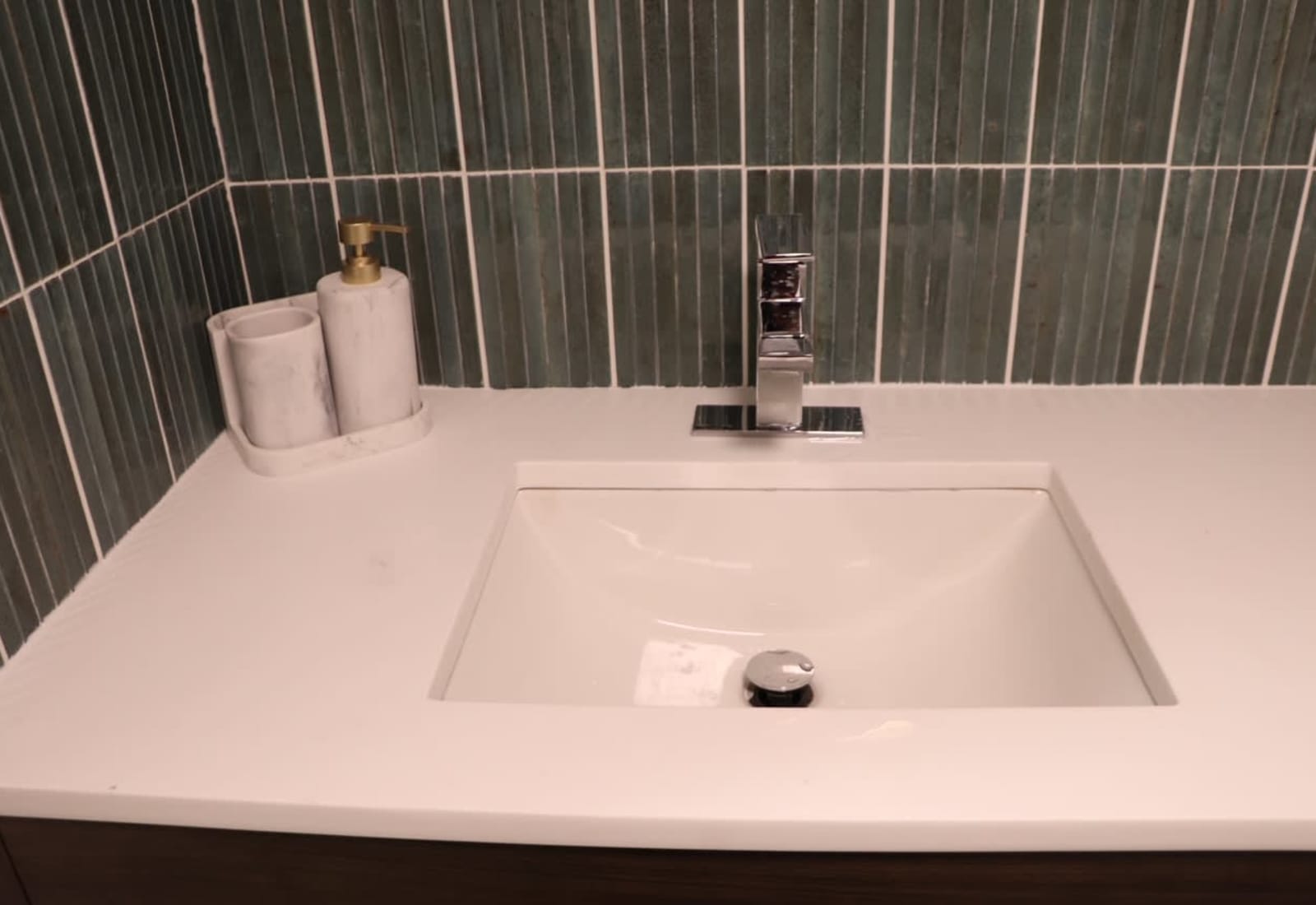 Freshen up at this sleek, modern vanity with a stylish green tile backsplash!