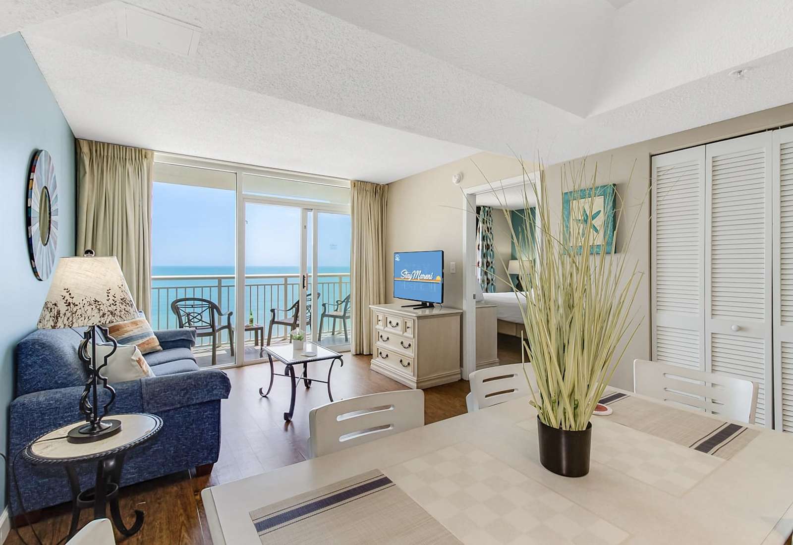 Enjoy breathtaking ocean views from this open and airy living and dining area. Relax on the plush sofa, dine in style, or step onto the private balcony for a perfect beachside retreat. 