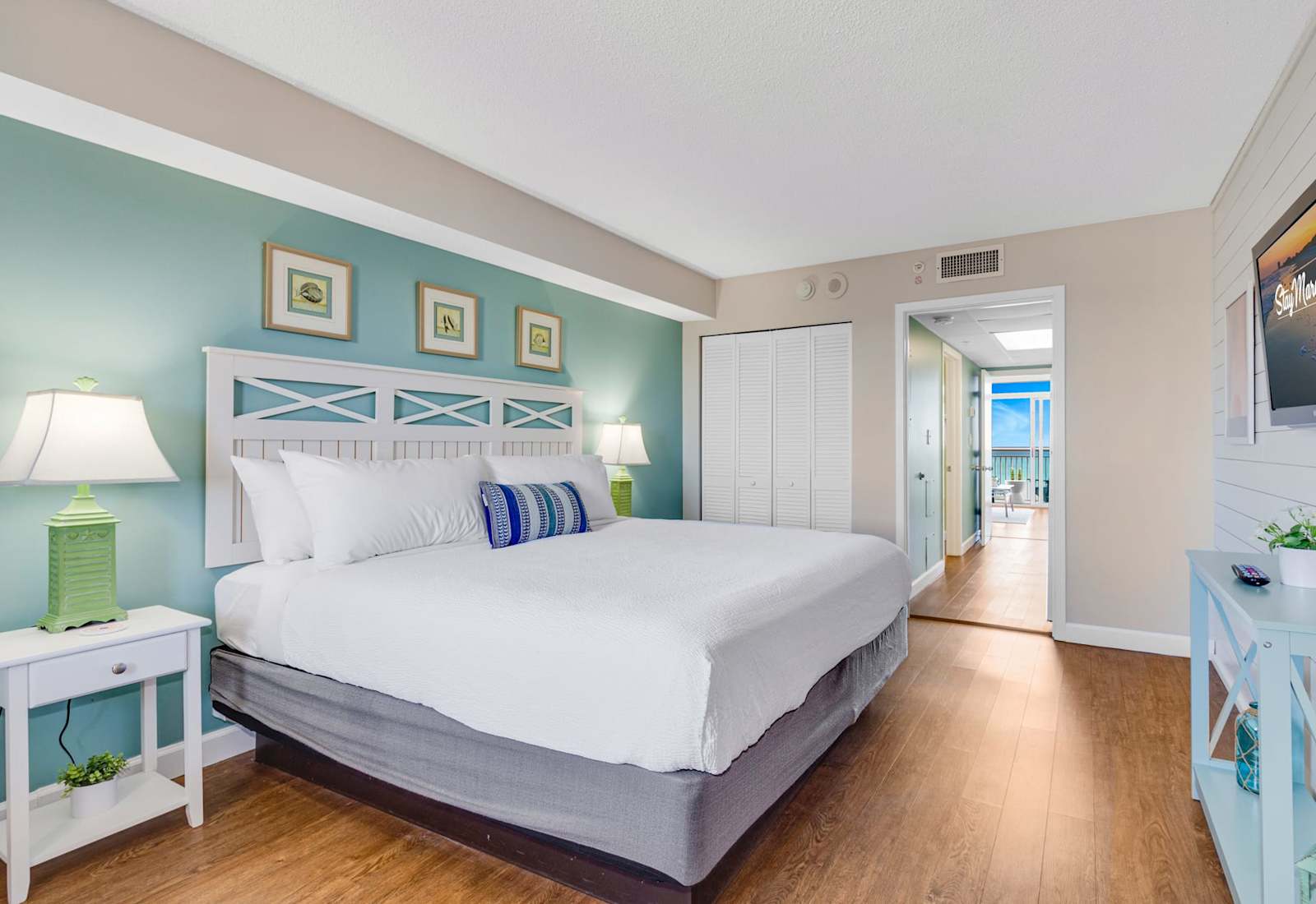 Relax in style in this serene bedroom featuring a plush king-sized bed, soothing coastal decor, and ample natural light. Drift off to the sound of the waves and wake up refreshed, just steps away from breathtaking ocean views. 