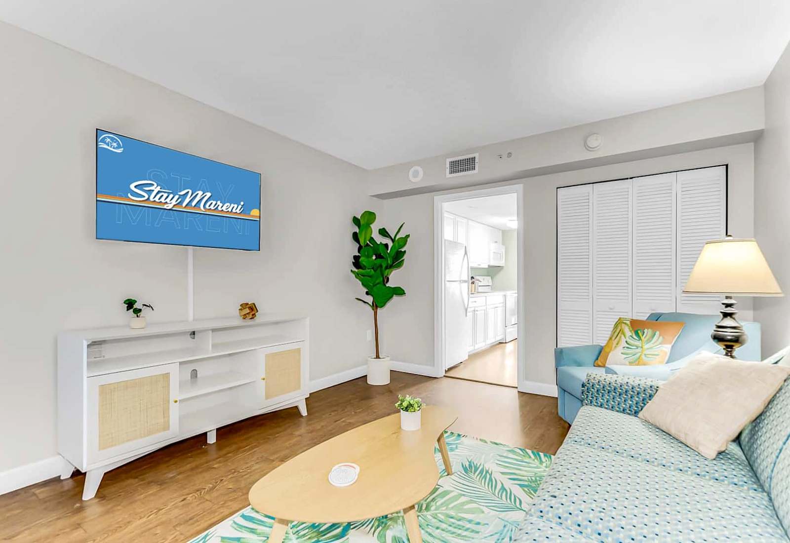 Unwind in this cozy and bright living room featuring tropical decor, a comfy seating area, and a flat-screen TV. Perfect for relaxing after a day of adventure, with a seamless flow to the fully equipped kitchen for ultimate convenience.